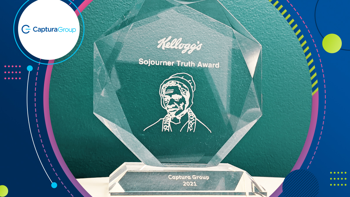 Blue with multicolored circles surround an image of a hexagon glass trophy featuring the silhouette of Sojourner Truth